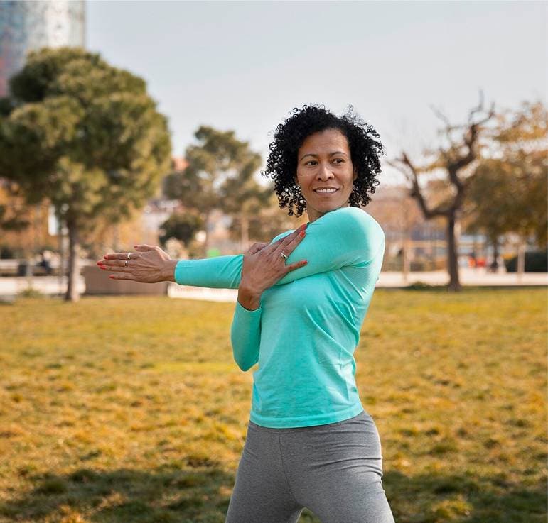 A woman stretching outdoors as part of an active, healthy lifestyle