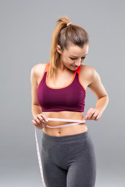 Woman measuring her waist to track medical weight loss progress