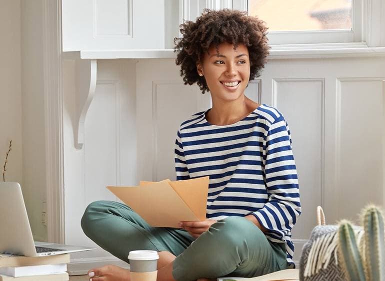 A woman reviewing paperwork at home
