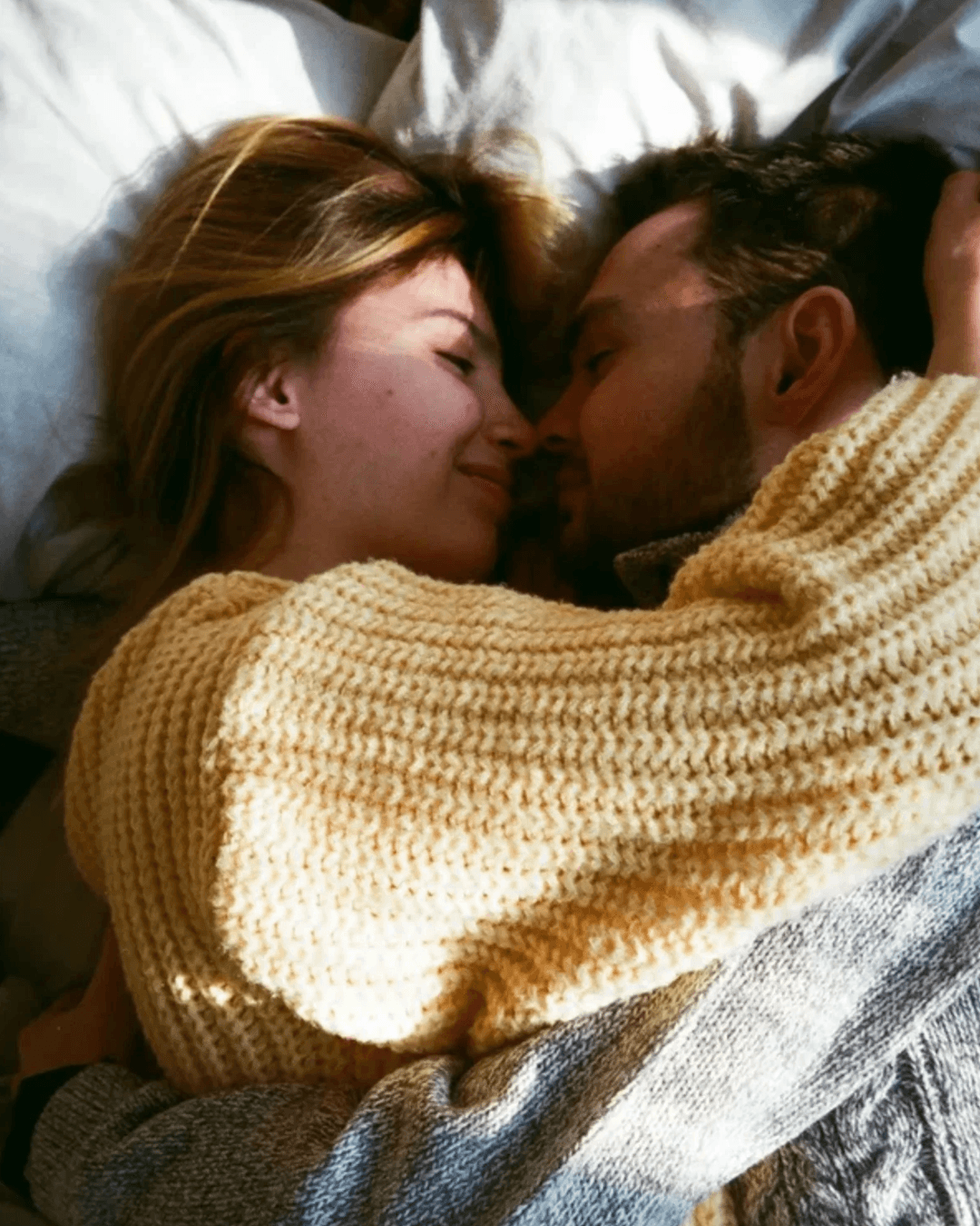 A couple embracing warmly in bed
